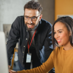 Teacher helps student on laptop