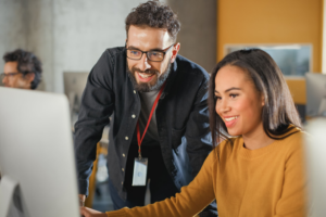 Teacher helps student on laptop